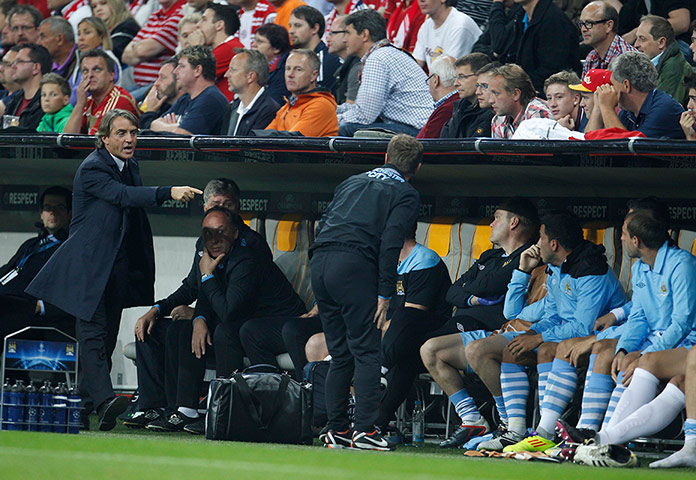 City versus United: Manchester City manager Roberto Mancini gestures towards his substitutes