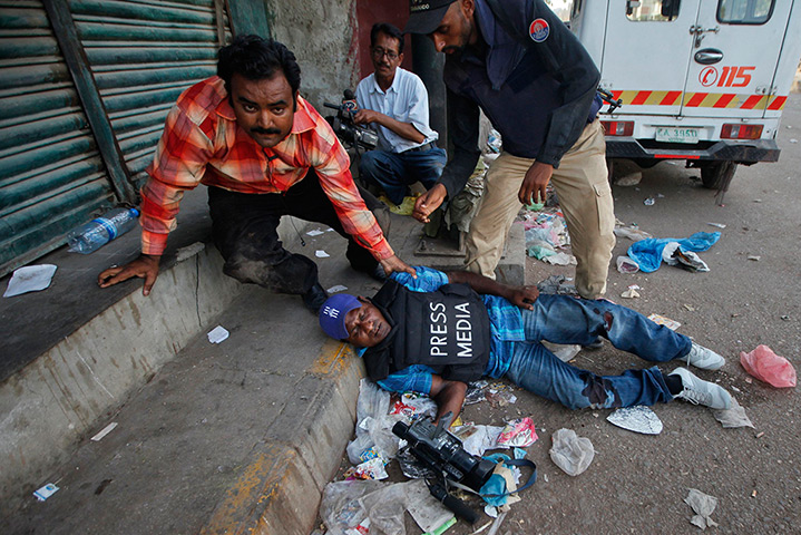 24 hours: Karachi, Pakistan: An injured cameraman is attended to during a fire fight