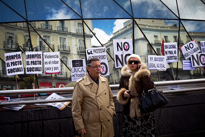 24 hours: Madrid, Spain: A couple watch a demonstration against spending cuts 