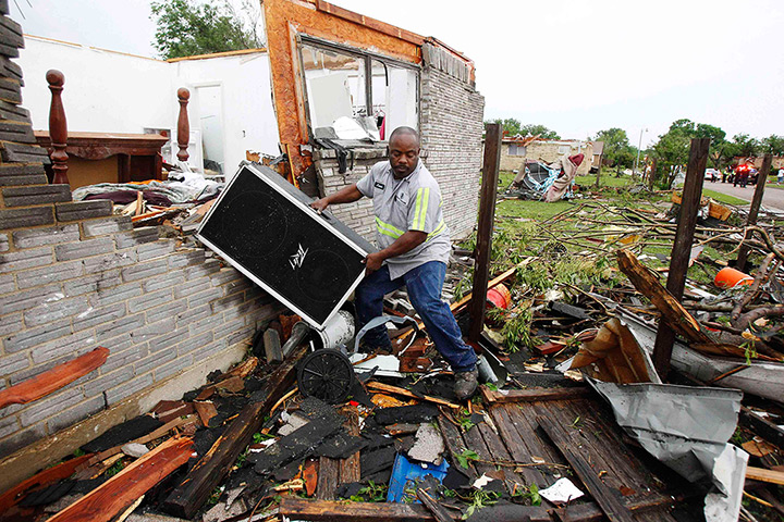 Texas tornado: Jason Moffett carries belongings out of a destroyed house