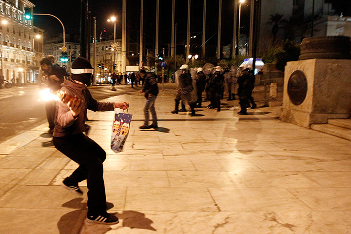 Greece unrest: A protester throws a molotov cocktail at riot police