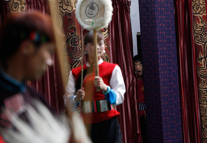 FTA: How Hwee Young: A performer of the Naxi ethnic minority peeps out from behind a curtain