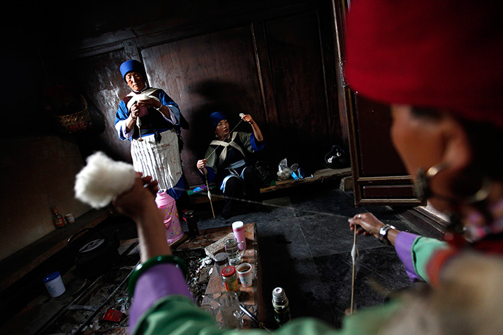 FTA: How Hwee Young: Performers spin cotton in the traditional way in a room backstage 