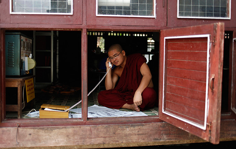 24 hours in pictures: A Buddhist monk talks on the phone in a monastery 