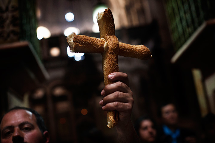 Good Friday traditions: Jerusalem: A Catholic worshipper holds a cross made out of bread 