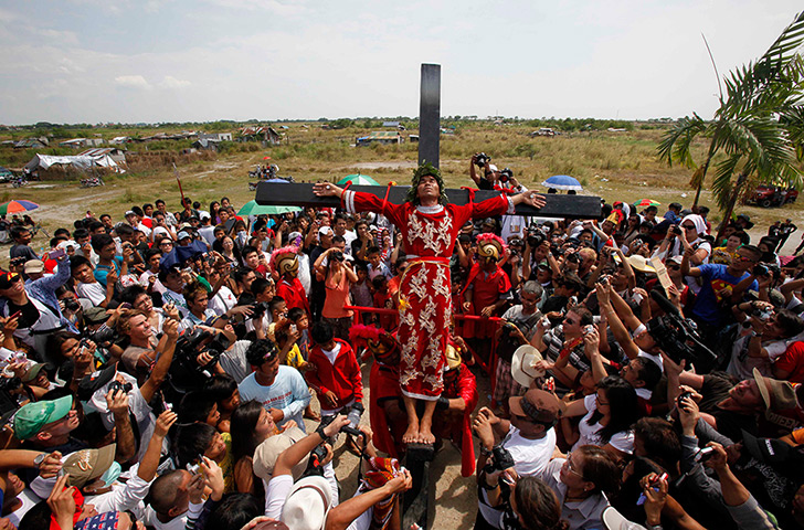 Good Friday traditions: San Pedro Cutud, Philippines: A man is hoisted on a cross by volunteers 