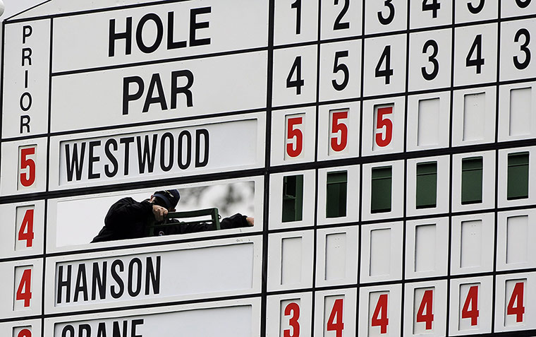 Augusta day 2: An operator works on the large manual scoreboard behind the seventh hole