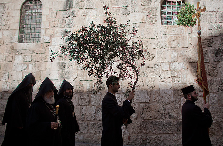 Easter Sunday: Orthodox Christian clergyman carries a branch of a olive tree Jerusalem