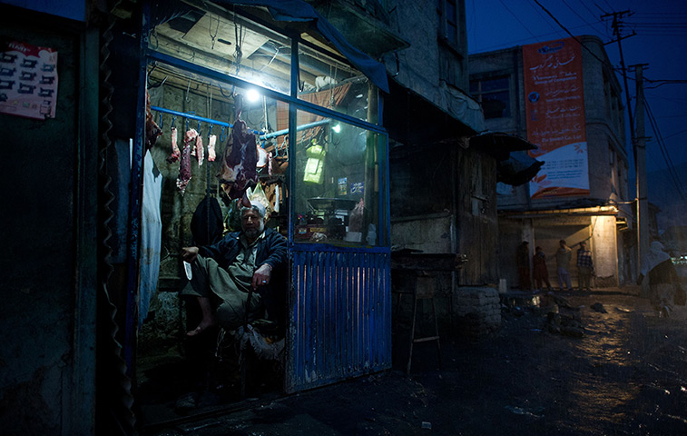 24 hours in pictures: An Afghan butcher sits in his shop in Kabul