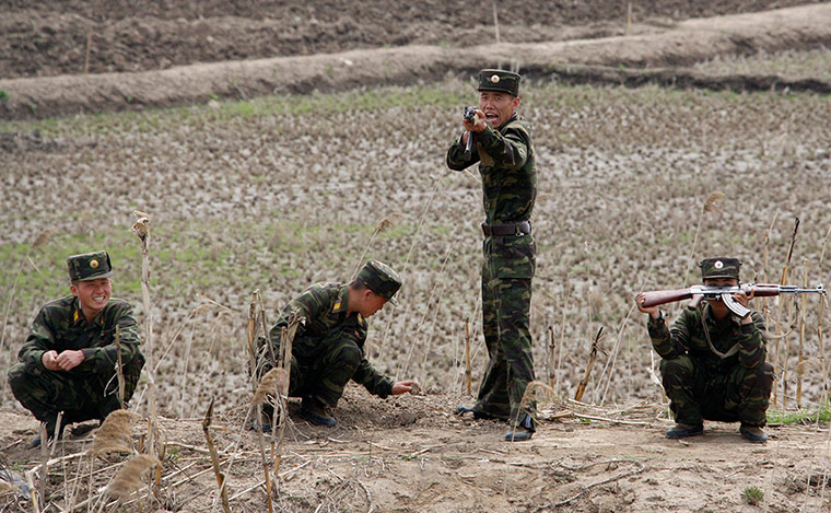 Picture Desk Live: Armed North Korean soldiers joke with Chinese tourists
