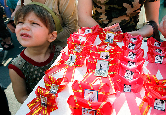 May Day 2012: Kiev: A Ukrainian boy helps his mother to sell traditional red bows