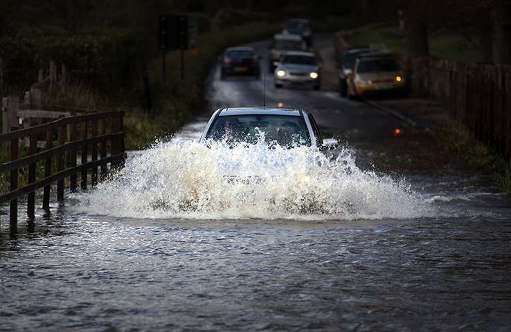 24 hours in pictures: A car makes its way through flood water during the wettest on record in UK