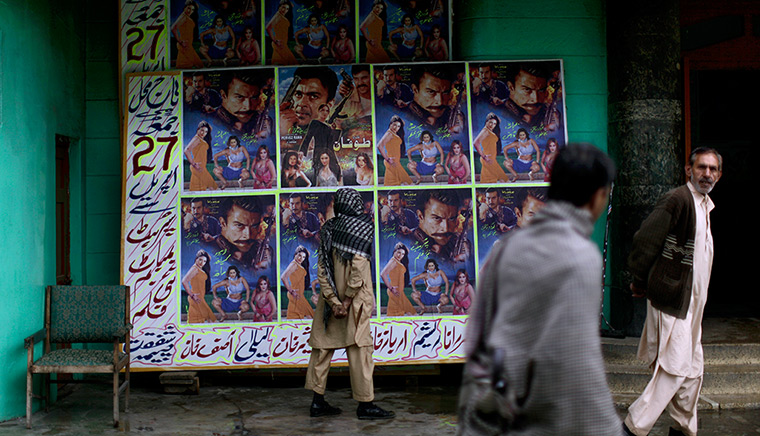 Abbottabad one year on: A man looks at a board outside the Taj Mahal cinema