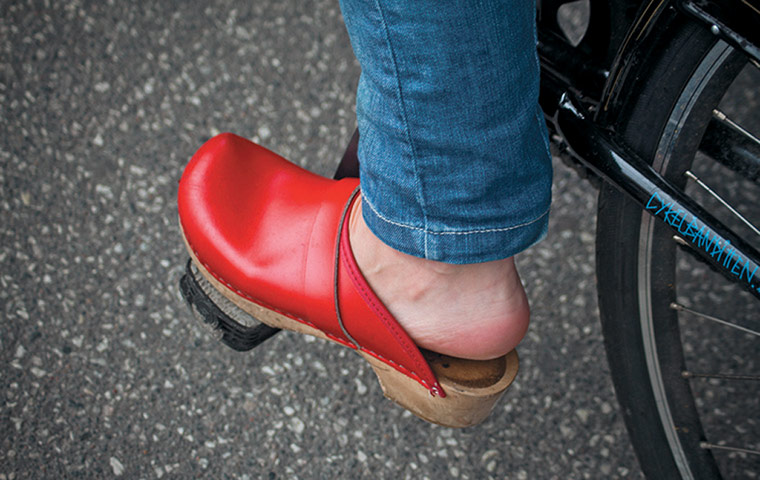 Big Picture, bikes: Big Picture: close of woman weather a red clog on a pedal