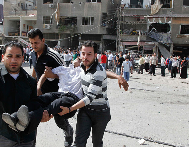 Picture Desk Live: An injured man is carried after an explosion in Damascus