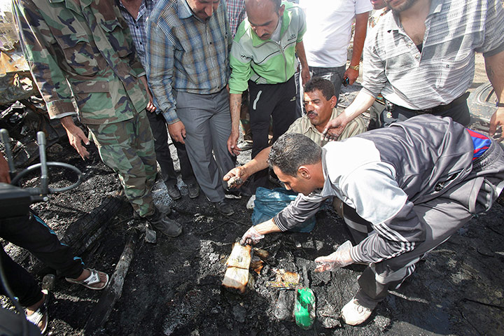 Damascus Bombs: Men clear debris at a security compound where the bombs exploded