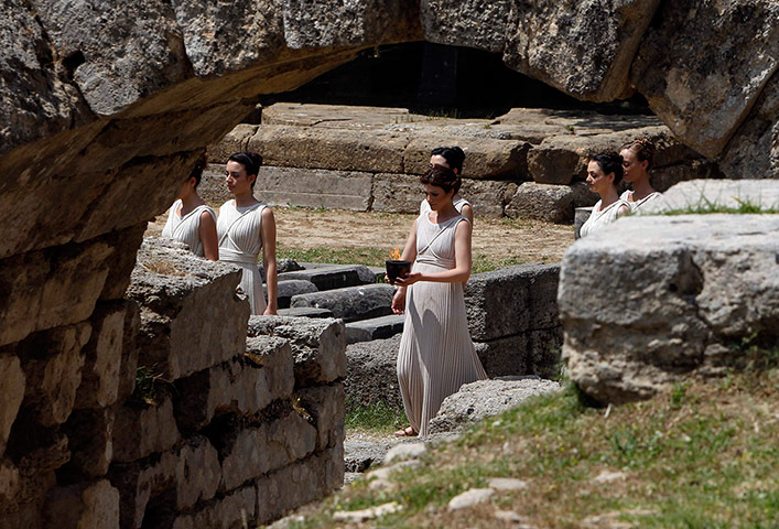 Olympic Torch: A 'priestess' carries a cauldron with the Olympic flame