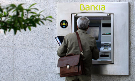 A man uses a Bankia cash dispenser