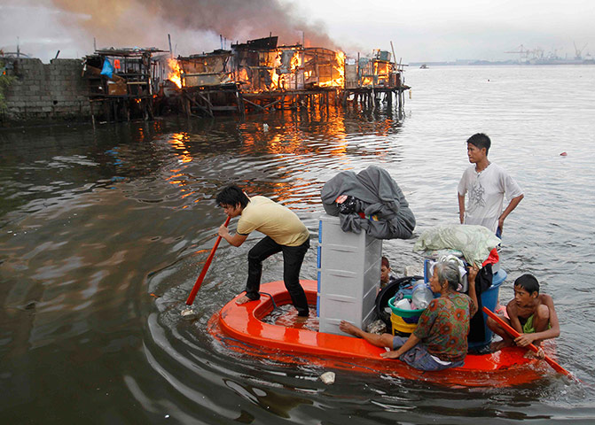 Manila: Residents paddle their makeshift boat to safety 