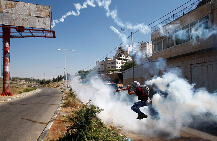 24 hours: A protester throws a tear gas canister fired by Israeli soldiers 