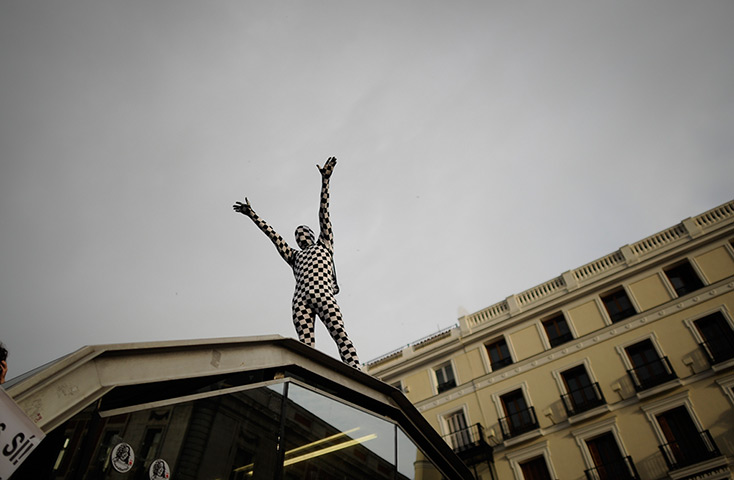 Spain protests: A Spanish indignant protester stands on top of a subway station