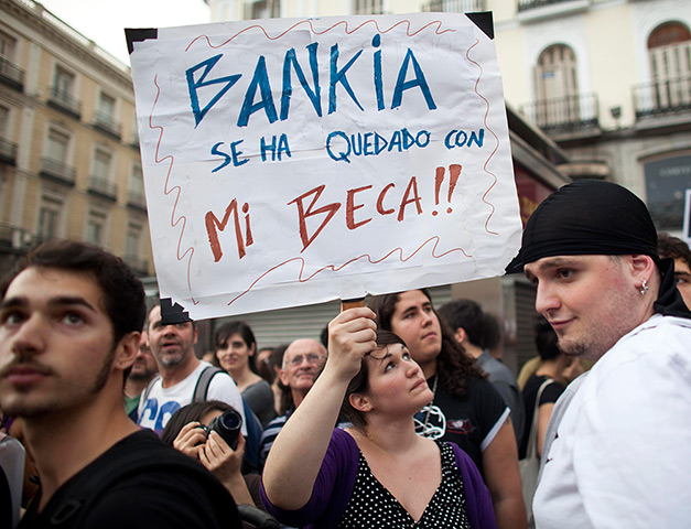 Spain protests: A demonstrator holds up a sign reading 'Bankia took my scholarship'