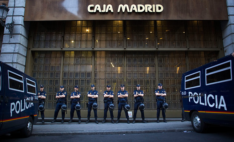 Picture desk live: Riot police guard a branch of the national bank in Madrid