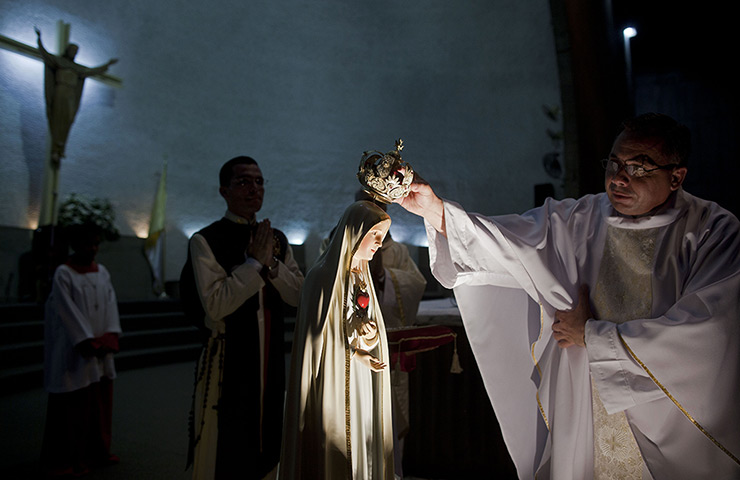 24 hours: Managua, Nicaragua: A priest places a crown on Our Lady of Fatima