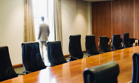 businessman stood by window