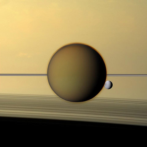 A month in space:  Titan's dense atmosphere shrouds the moon beneath a tan haze