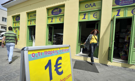 A woman exits a one euro shop in central Athens