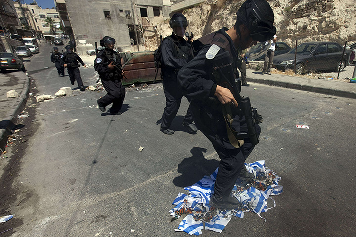 24 hours: Jerusalem: An Israeli policeman extinguishes burning Israeli flags