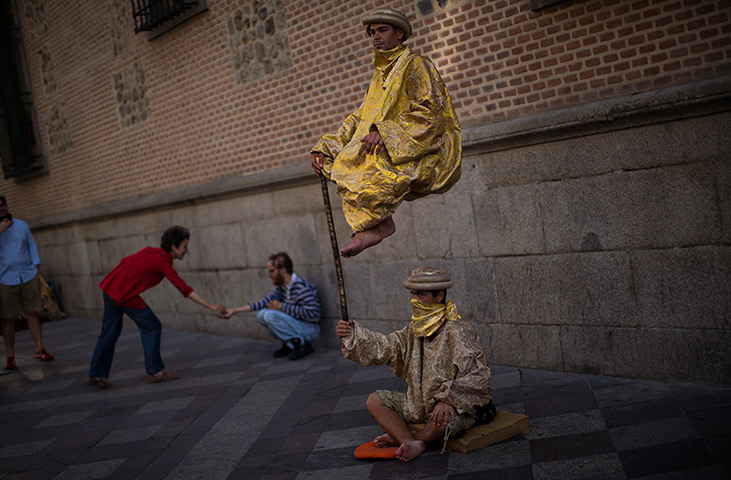 24 hours: Madrid, Spain: Men perform as they beg for charity in a street