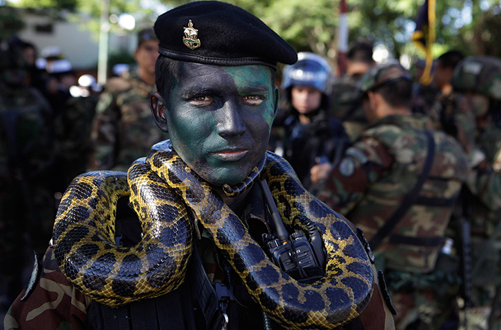 24 hours: Asuncion, Paraguay: A Marine officer poses for a photo with a snake