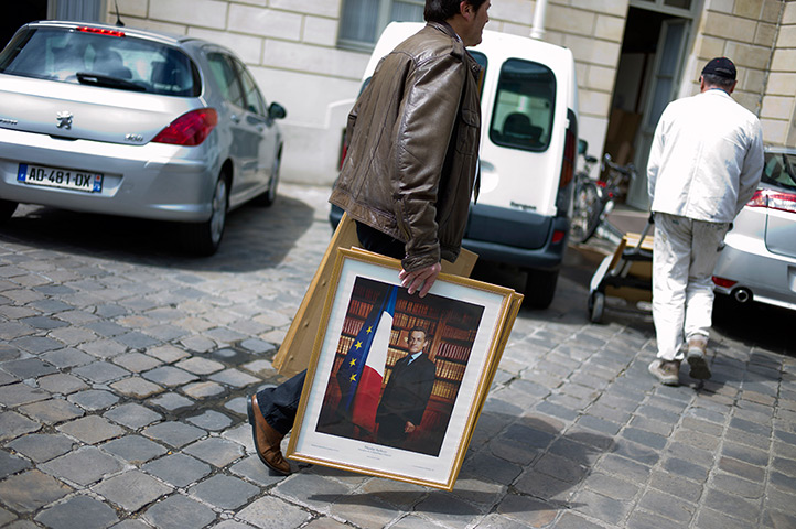 Hollande inauguration: A worker removes the official portraits of former President Sarkozy