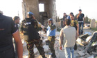 Members of the UN observer mission in Syria are seen between destroyed houses in Sermeen, near Idlib