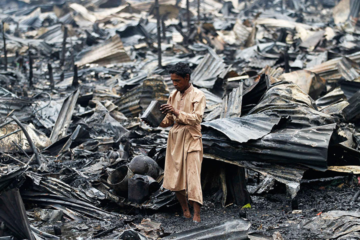 Picture desk live: A man salvages his belongings after a fire in a slum at Shyamoli in Dhaka