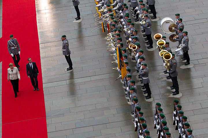 24 hours: Berlin, Germany: Angela Merkel and Francois Hollande review honour guards
