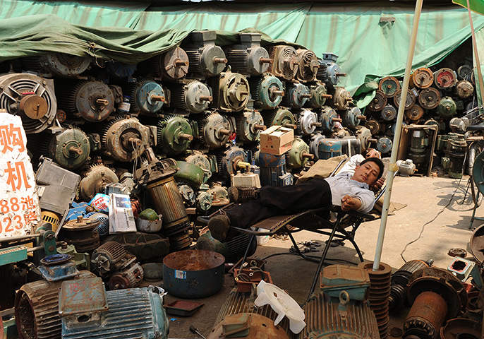 24 hours: Shanghai, China: A worker takes a break at his workshop 