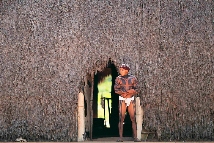 FTA: Ueslei Marcelino: A Yawalapiti man walks out of a hut