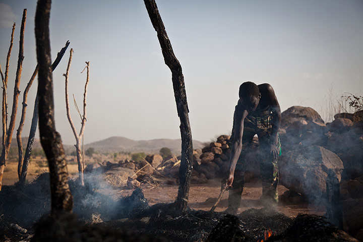 Nuba Mountains Conflict: A man in the remains of a house destroyed by Sudan Armed Forces in Tabanya