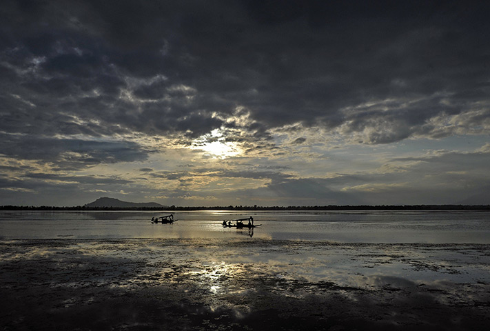 24 hours: Srinagar, India: Boats on Dal Lake on a windy and rainy day