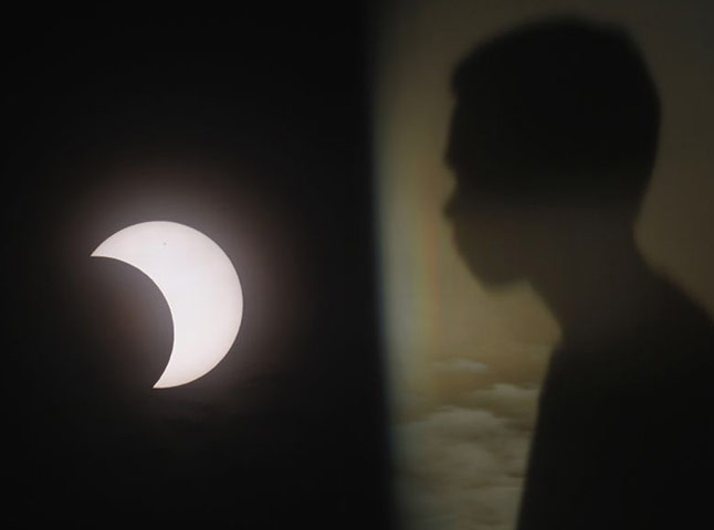 eclipse: A boy watches the partial eclipse in Manila, Philippines