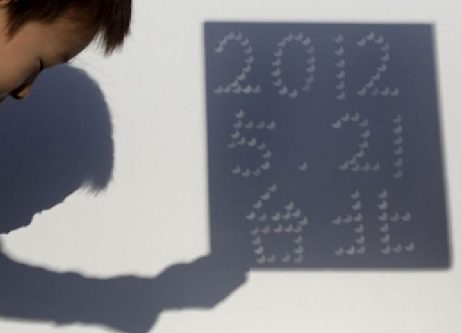 eclipse: The eclipse projected on to a wall to form the date and word 'Taipei'
