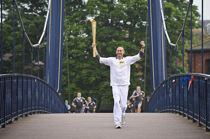 Olympic torch relay day 3: Paul Giblin carrying the Olympic torch across Cricklepit Bridge, Exeter