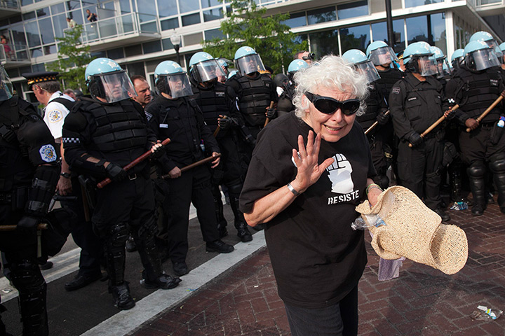 NATO summit protests: A woman asks for calm as she stands in front of a row of riot police 