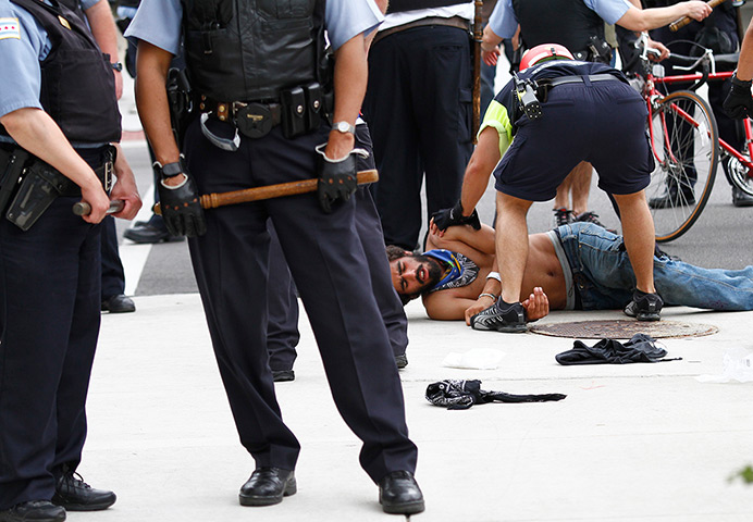 NATO summit protests: A demonstrator receives medical attention as he lies injured