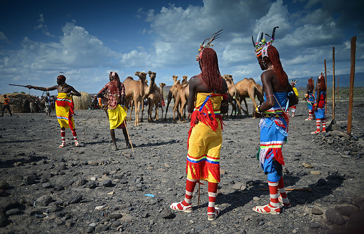 24 hours in pictures: Men from the Rendille tribe tend to camels at the Lake Turkana Festival