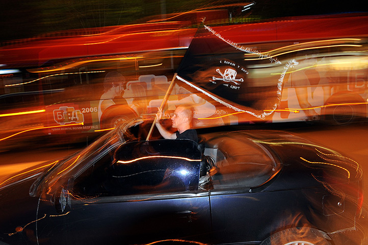 24 hours in pictures: A supporter of Serbia's newly elected President waves flag from car