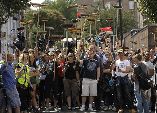 David Cameron celebrates: David Cameron helps with the clean up after the London riots